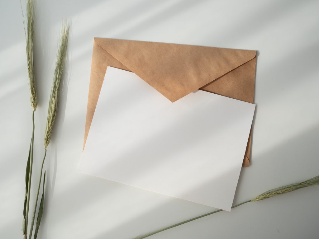 Brown envelope with white paper representing staff letters for employer using Pension Automatic Enrolment