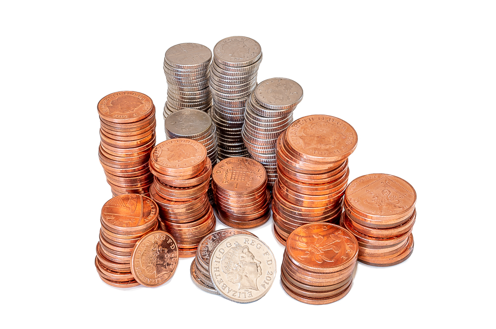 Piles of English coins on a white background.