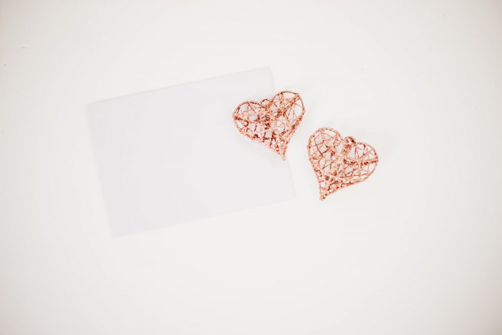 We love payroll represented by 2 pink wire hearts and a piece of paper or envelope.